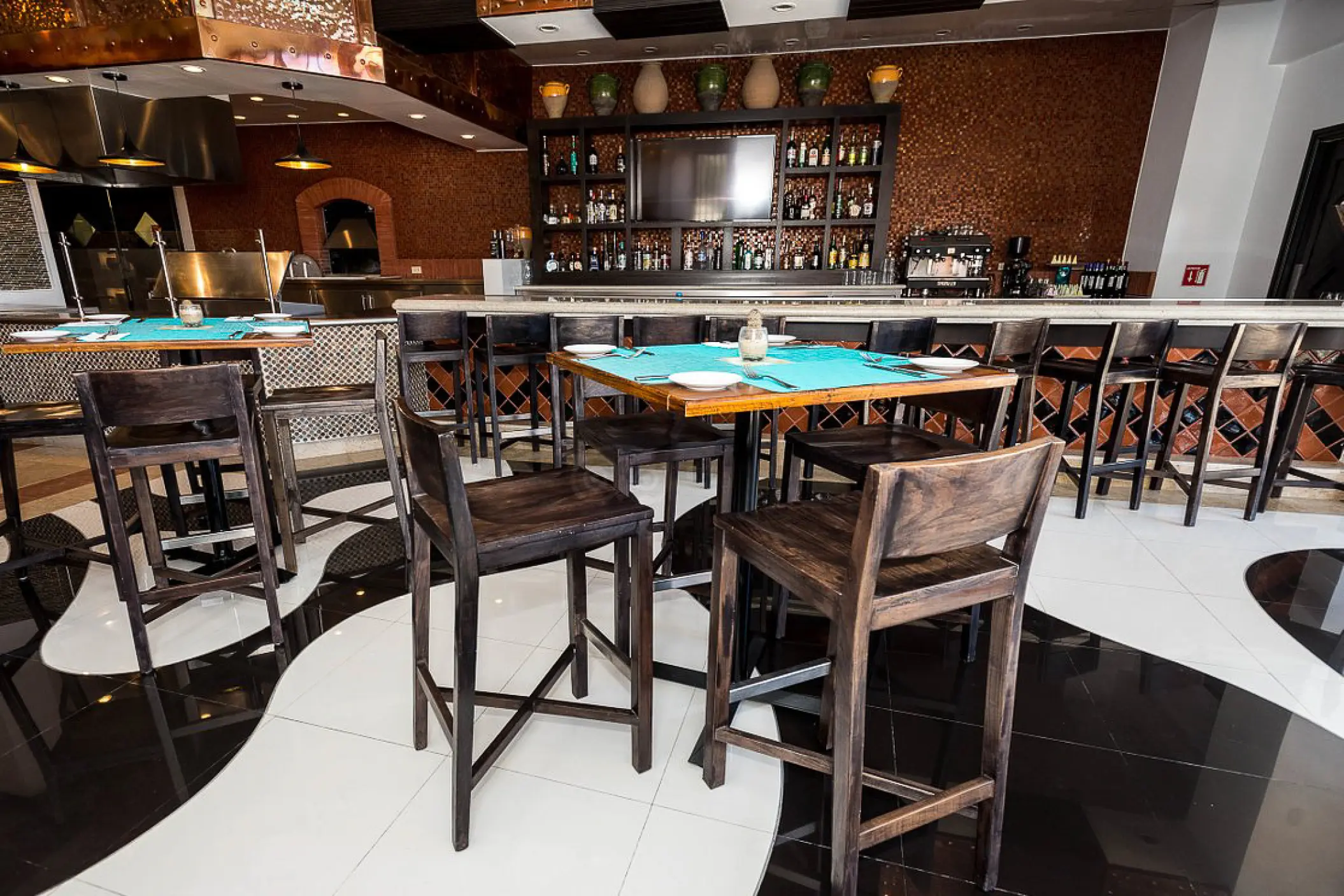 Bar and dining area with high-top wooden tables at Hyatt Sirena del Mar, Cabo San Lucas