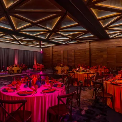 Indoor wedding reception with round tables and geometric ceiling at Solaz Los Cabos, Cabo San Lucas