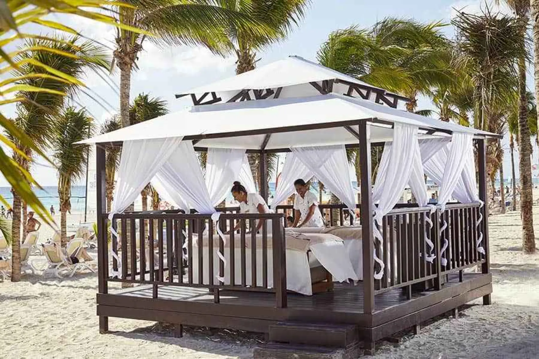 Beachfront spa cabana with white curtains and massage tables at Riu Palace Riviera Maya, Playa Del Carmen