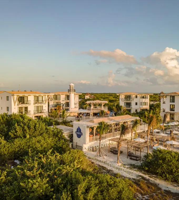St. Somewhere Holbox aerial view of resort buildings and beach club surrounded by lush greenery, Isla Holbox
