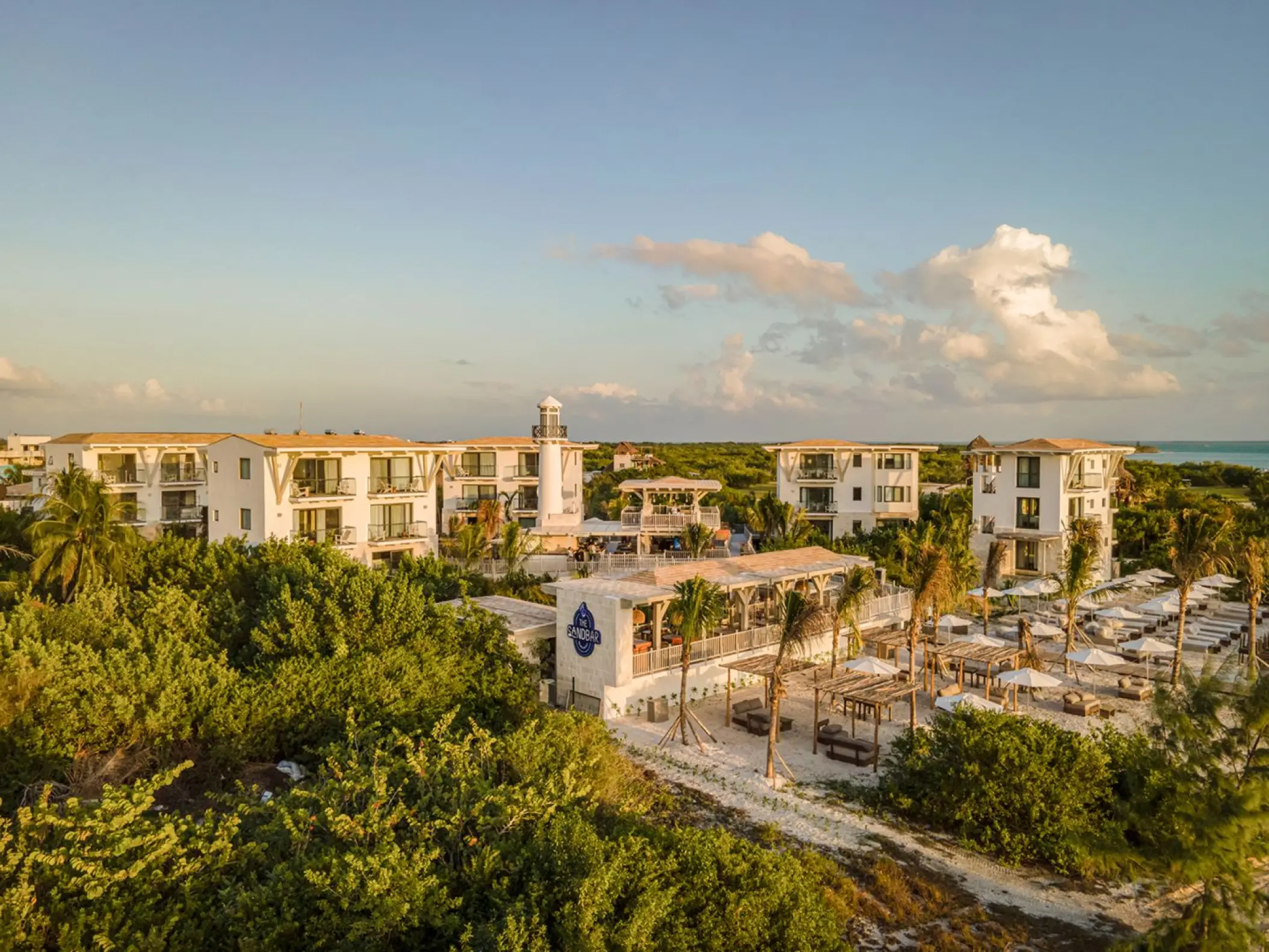 St. Somewhere Holbox aerial view of resort buildings and beach club surrounded by lush greenery, Isla Holbox