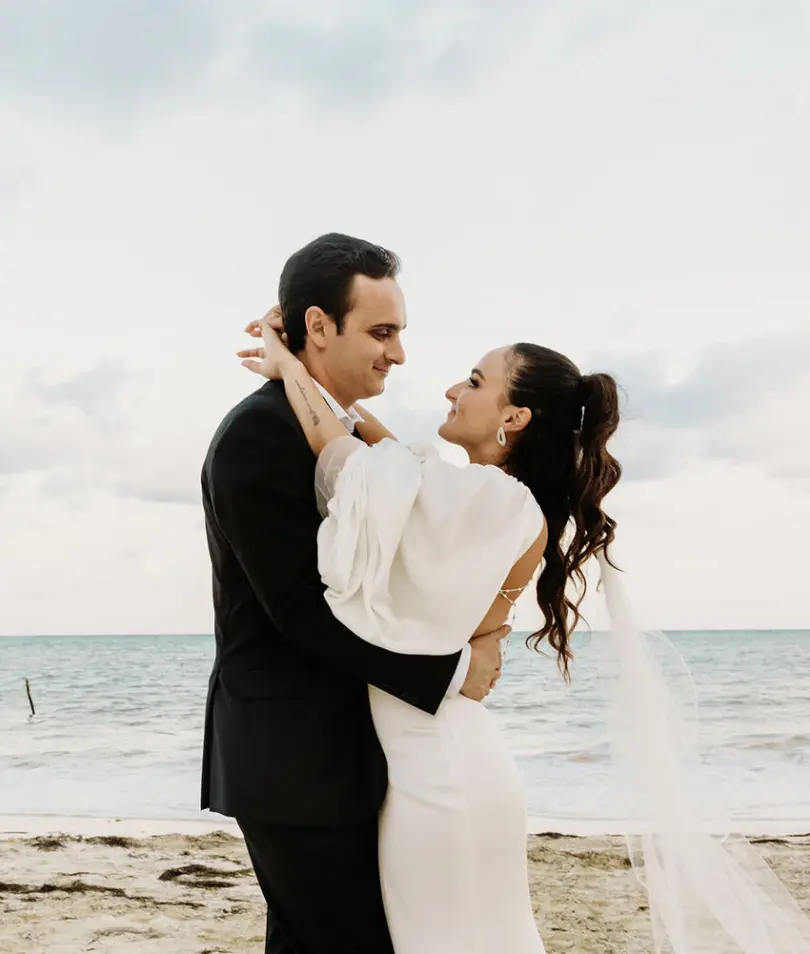 Alyssa & Ryan embracing during their beach wedding ceremony portrait