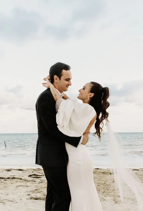 Alyssa & Ryan embracing during their beach wedding ceremony portrait