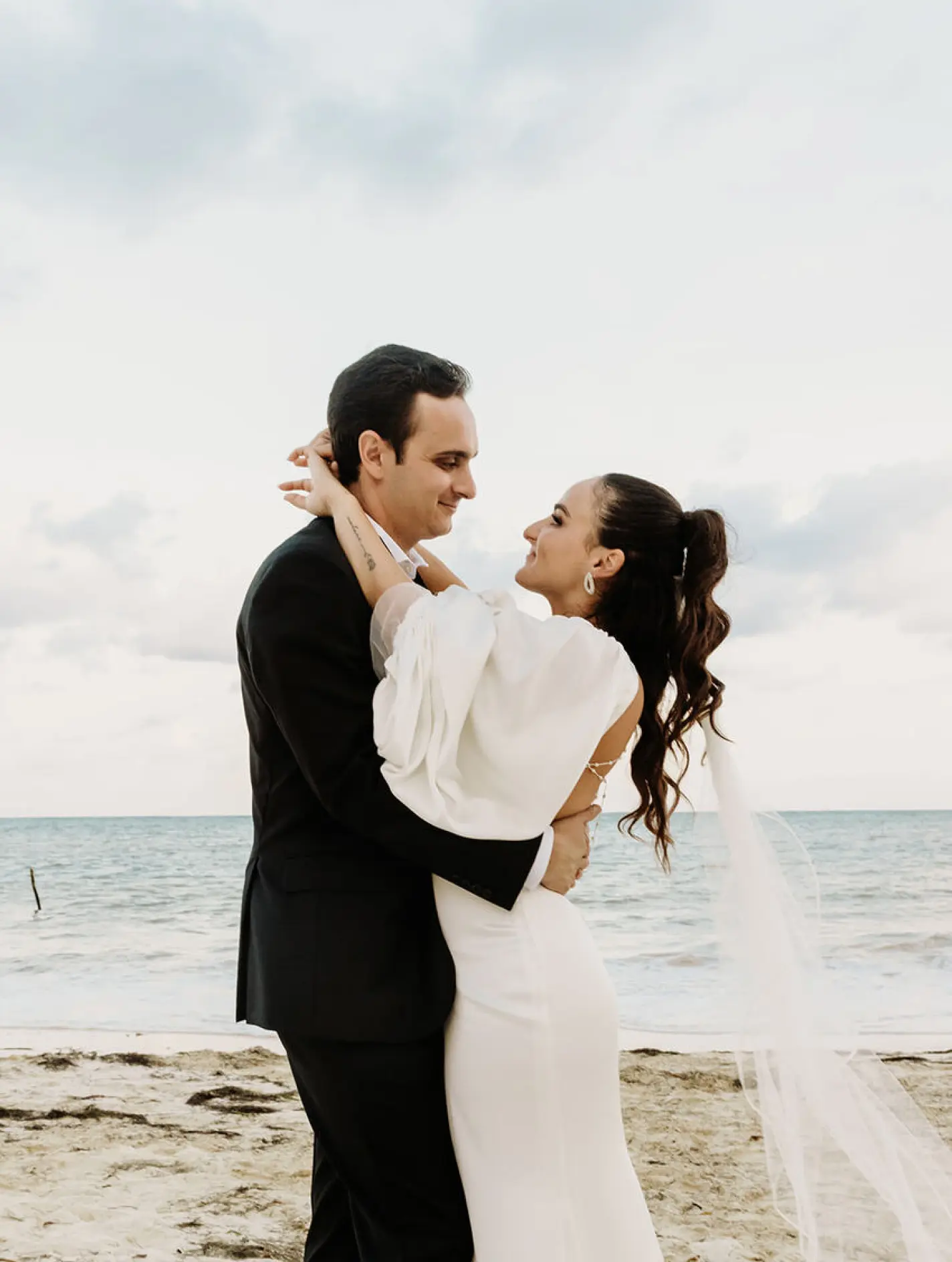 Alyssa & Ryan embracing during their beach wedding ceremony portrait