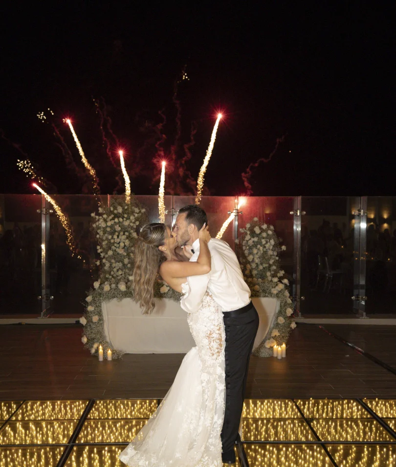 Andreana and Alessandro share a kiss during wedding fireworks