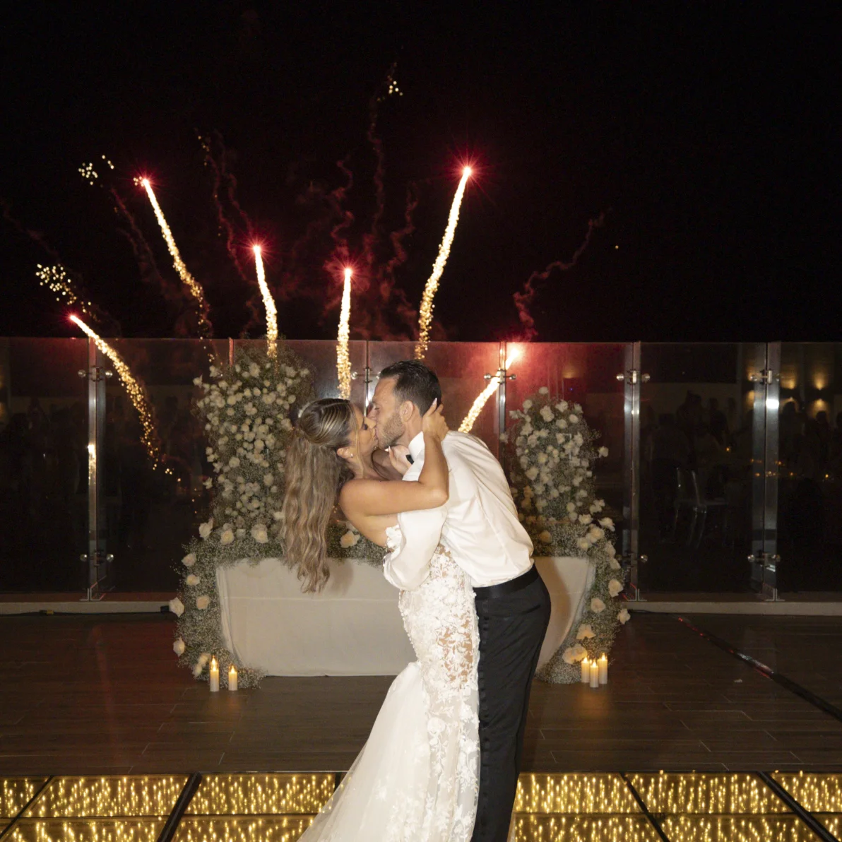 Andreana and Alessandro share a kiss during wedding fireworks