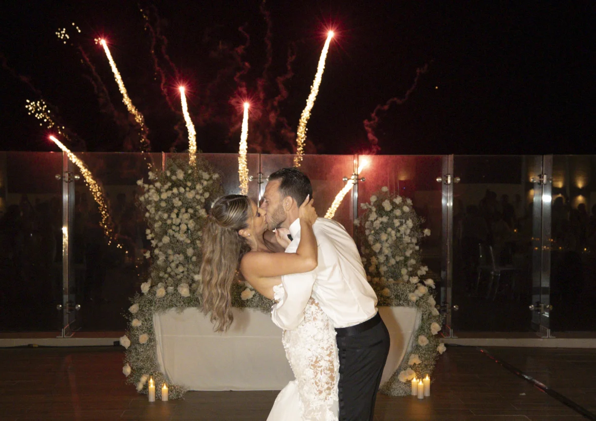Andreana and Alessandro share a kiss during wedding fireworks