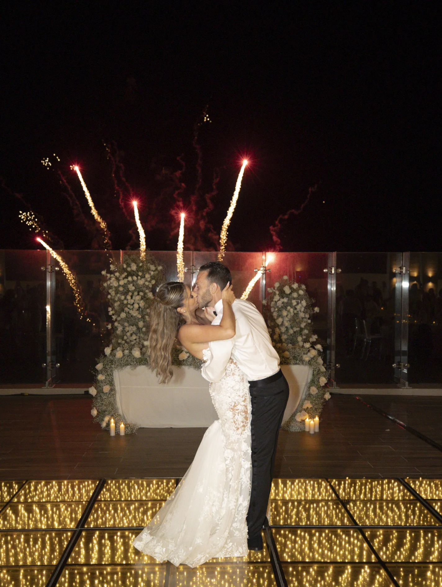 Andreana and Alessandro share a kiss during wedding fireworks