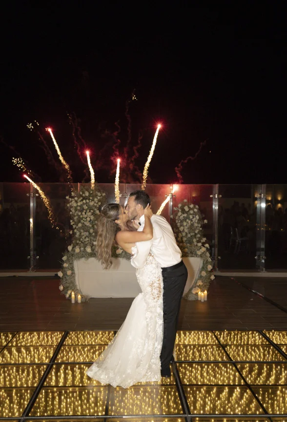 Andreana and Alessandro share a kiss during wedding fireworks