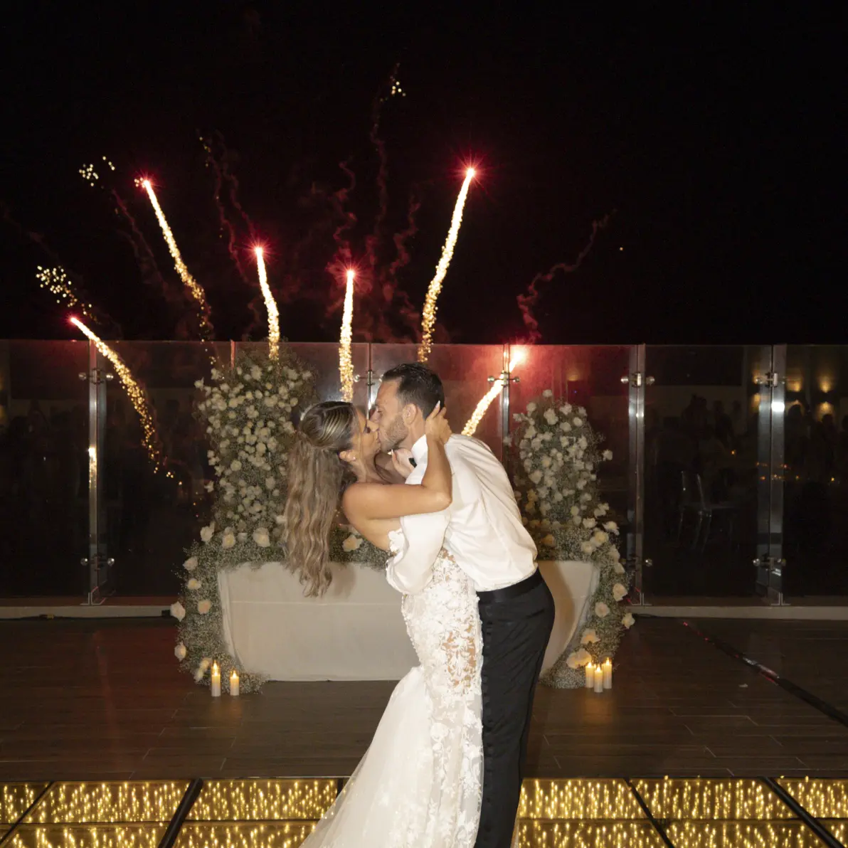 Andreana and Alessandro kiss on a light-up dance floor during wedding fireworks at Royalton Splash Riviera Cancun