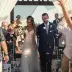 Casey walking down the aisle while guests toss petals at her wedding ceremony