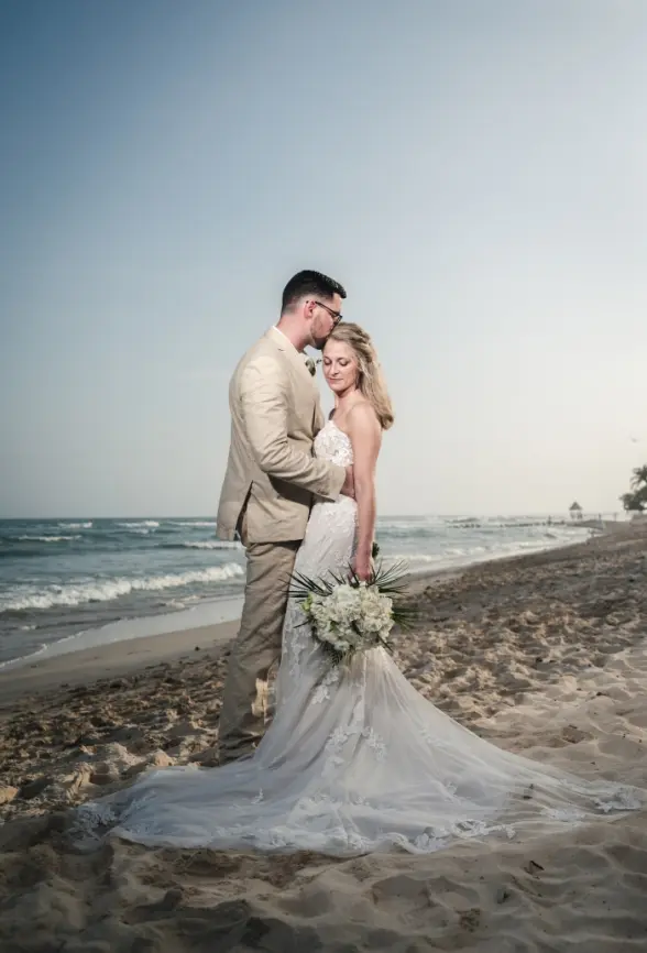Danielle & Derrek's beach portrait with the groom kissing the bride's forehead