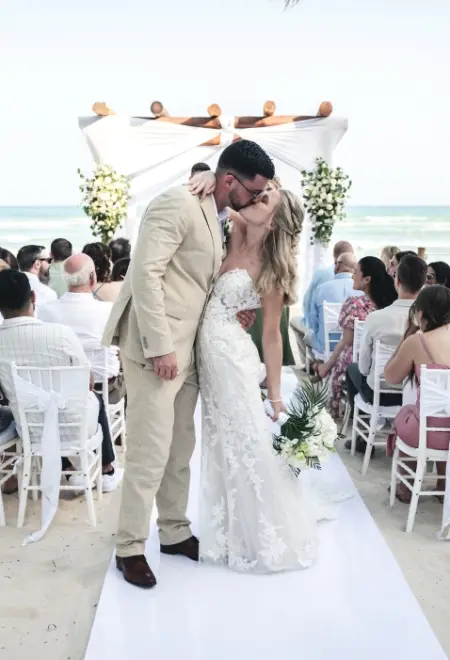 Danielle & Derrek kiss at their beach ceremony after walking down the aisle
