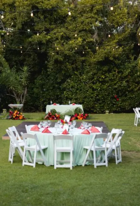 Outdoor garden wedding reception with string lights and white chairs at Dreams Tulum, Tulum