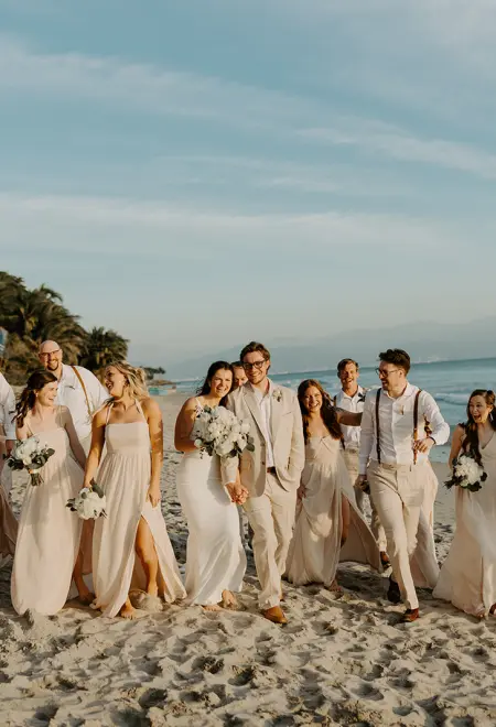 Stephanie & Austin walking along the beach with their wedding party at Secrets Bahia Mita, Puerto Vallarta