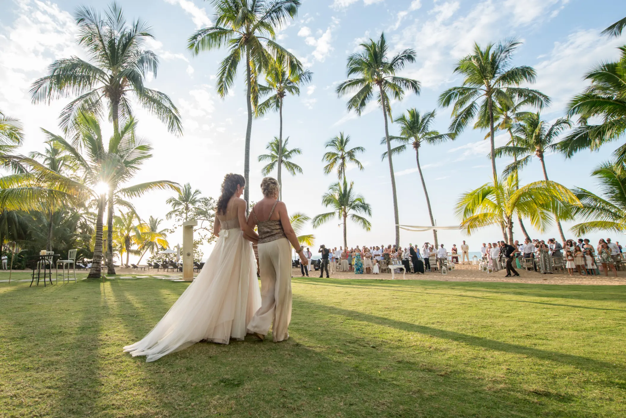 Bride walking across a lawn toward a beach ceremony at Sublime Samaná, Samana