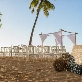 Beach wedding ceremony with white chairs and a huppah at Sublime Samaná, Samana