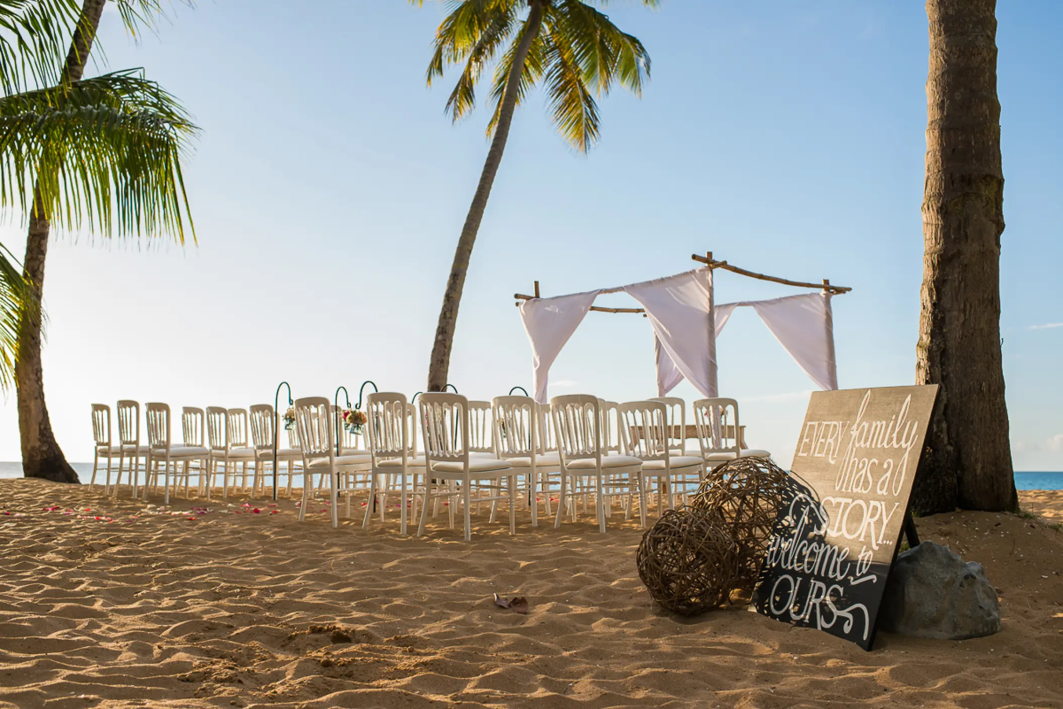 Beach wedding ceremony with white chairs and a huppah at Sublime Samaná, Samana