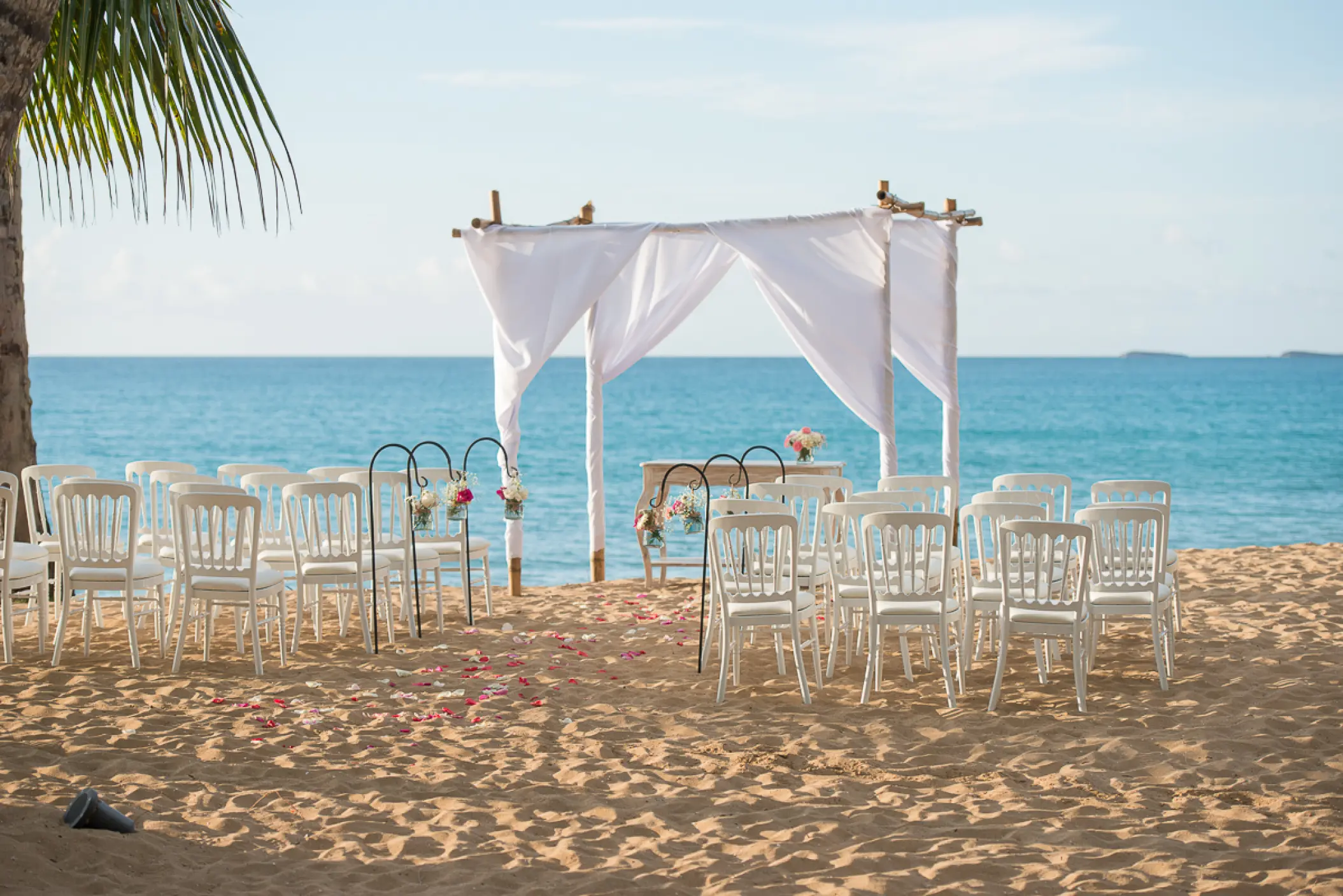 Beachfront wedding ceremony with white huppah and chairs at Sublime Samaná, Samana