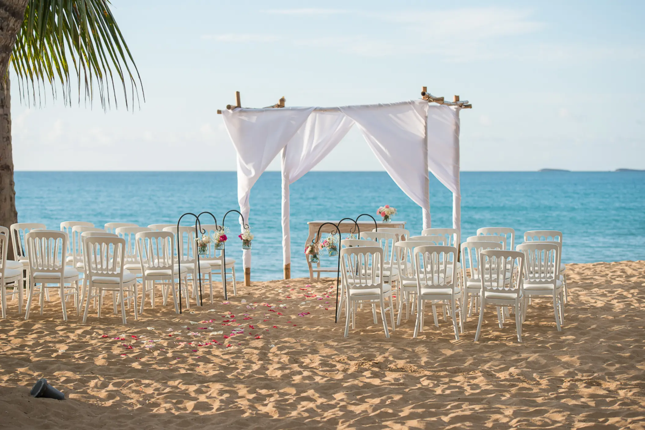 Beachfront wedding ceremony with white huppah and chairs at Sublime Samaná, Samana