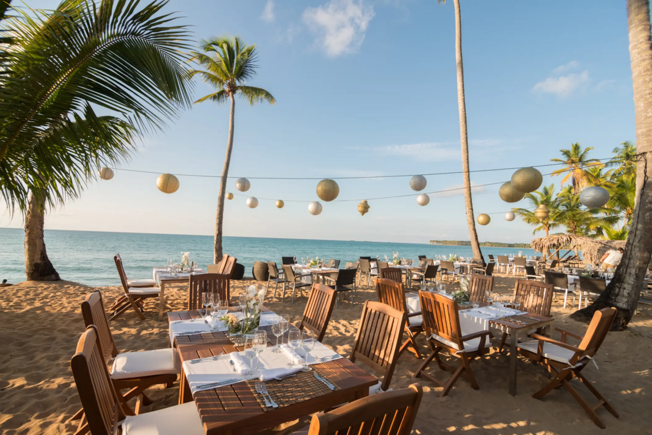 Beachfront wedding reception tables with paper lanterns at Sublime Samaná, Samana