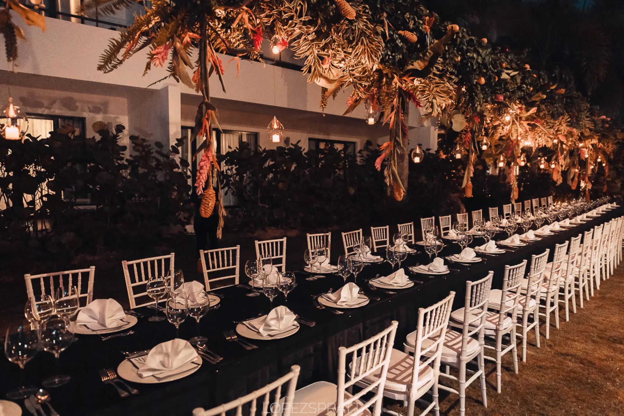 Long outdoor reception table with hanging tropical greenery at Sublime Samaná, Samana