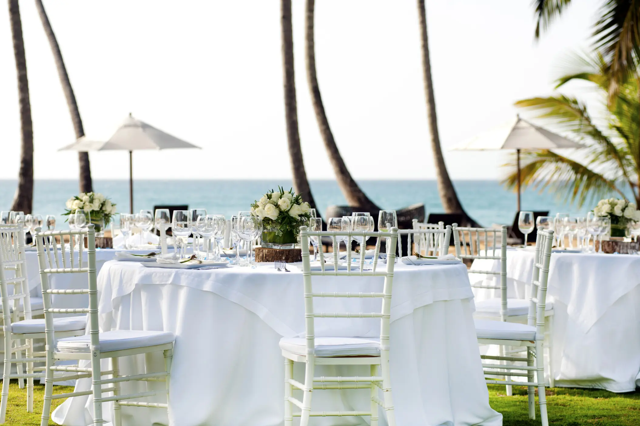 Outdoor wedding reception at Sublime Samaná, Samana with white table settings and palm trees