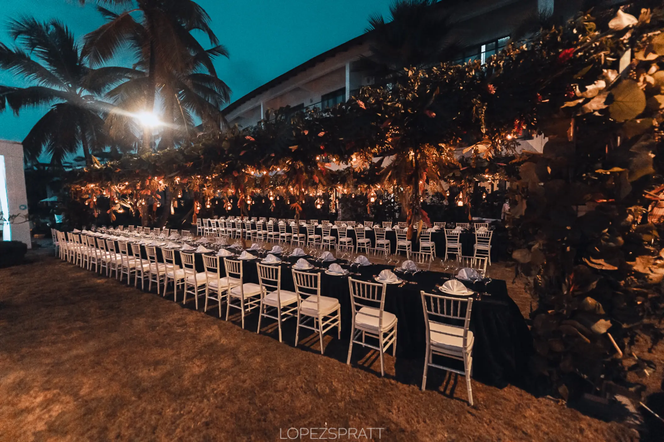 Outdoor wedding reception with long tables and string lights at Sublime Samana, Samana
