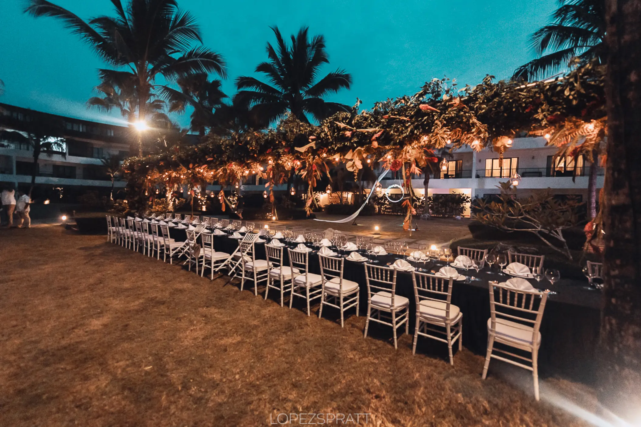 Outdoor garden wedding reception with long table and hanging lights at Sublime Samana, Samana