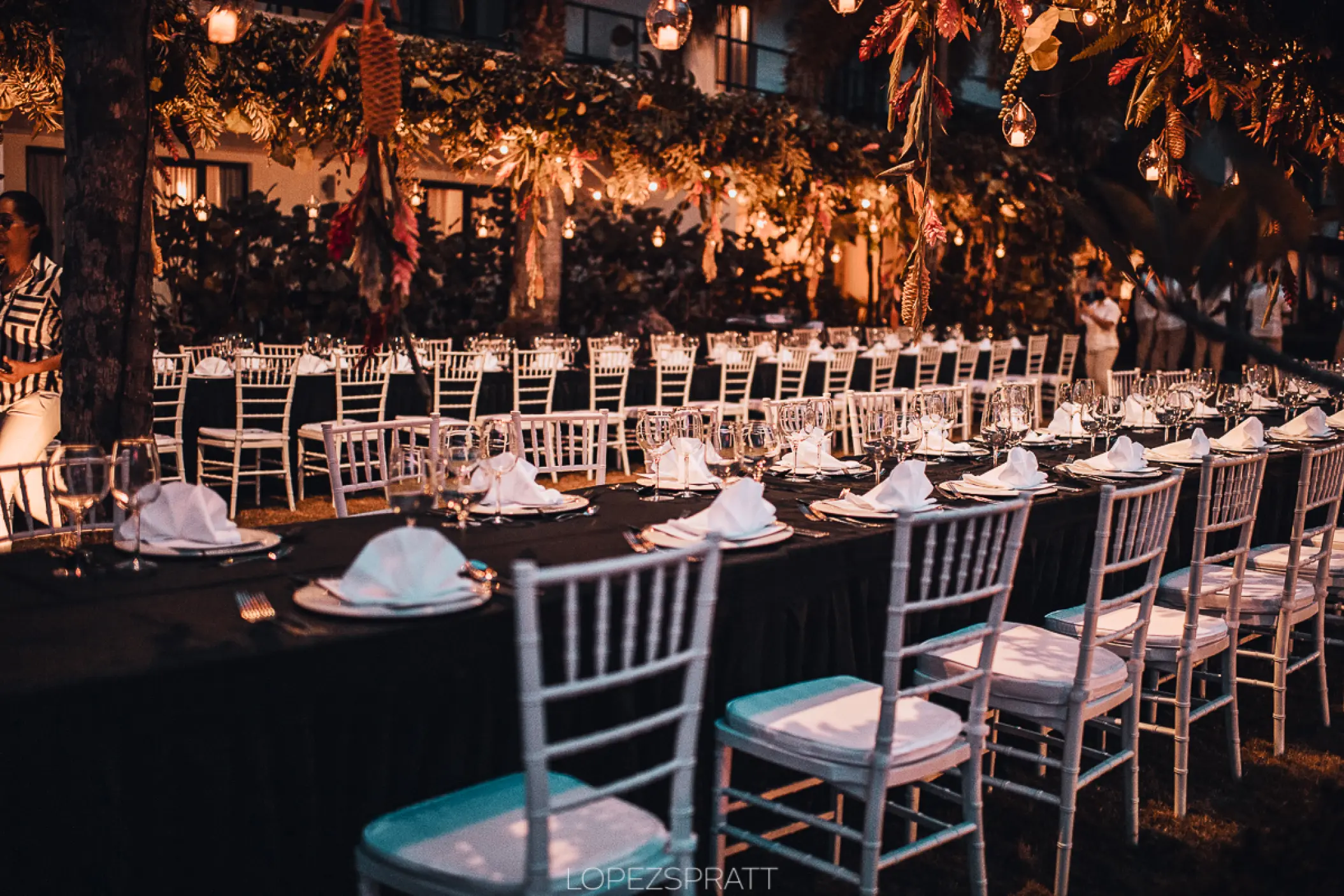 Garden wedding reception with long banquet tables and hanging lights at Sublime Samaná, Samana