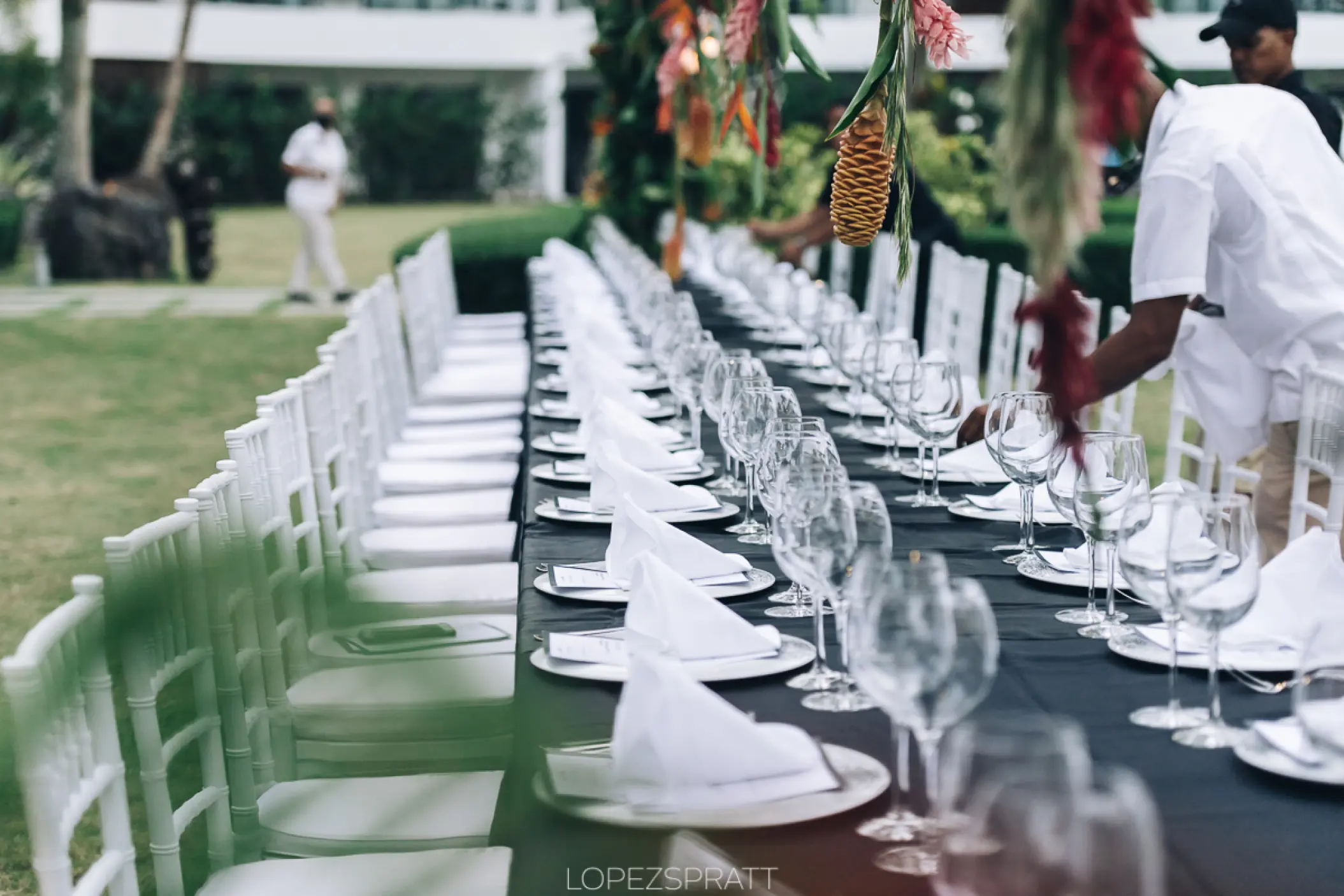 Outdoor wedding reception table with white chairs and hanging floral decor at Sublime Samaná, Samana