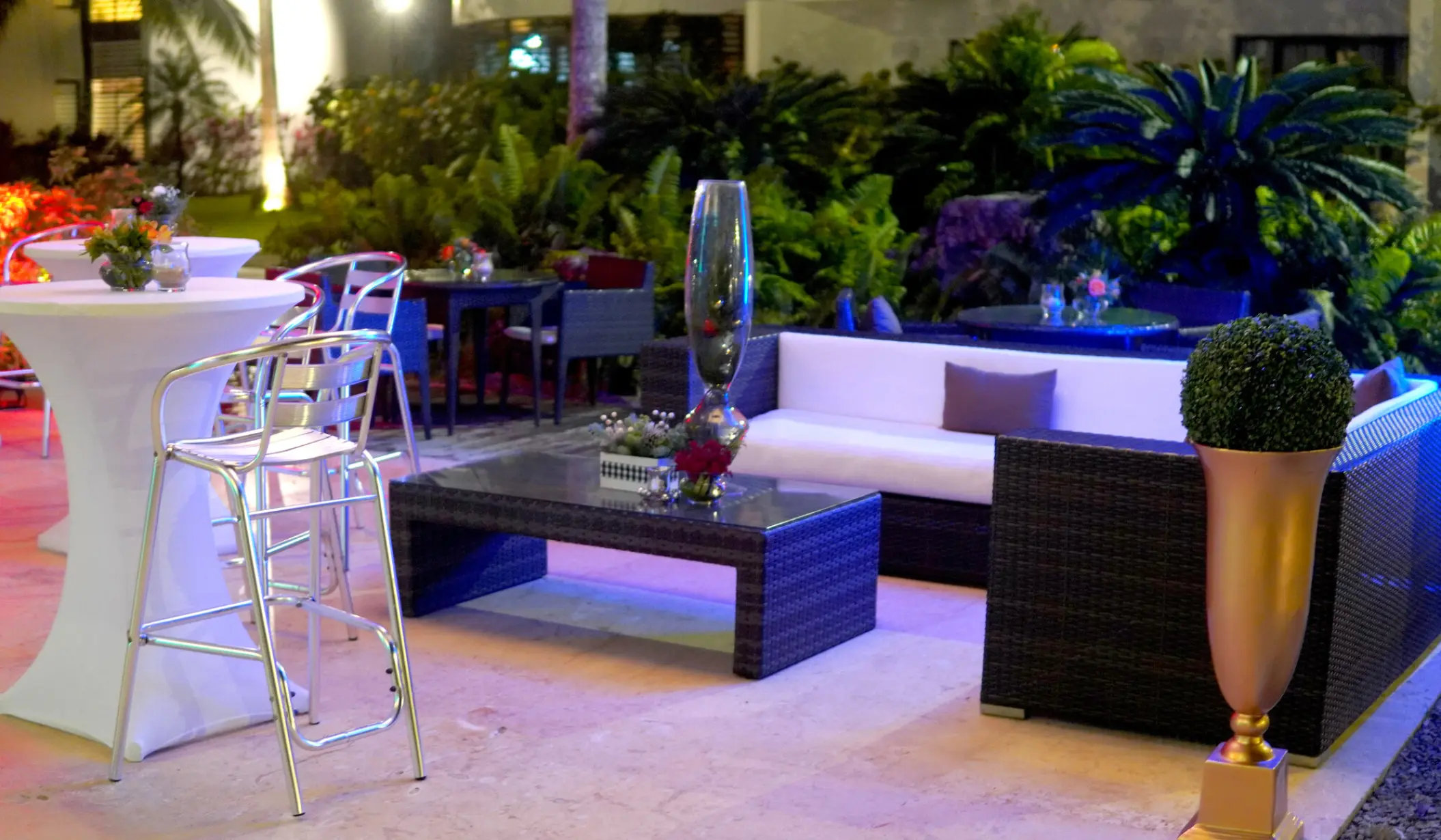 Outdoor cocktail reception lounge with wicker sofas and high-top tables at Sublime Samaná, Samana