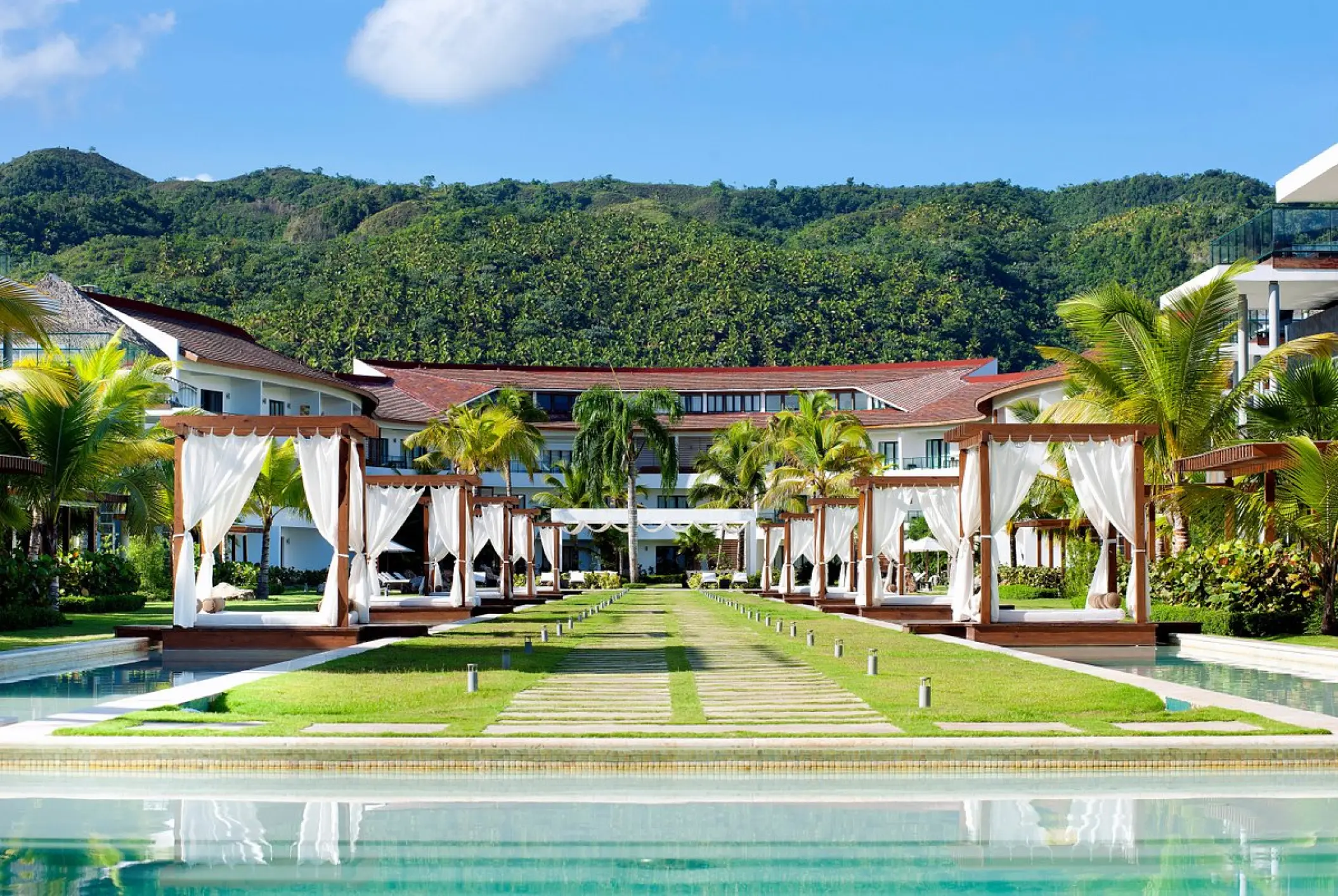 Resort buildings and poolside cabanas with white curtains at Sublime Samana, Samana
