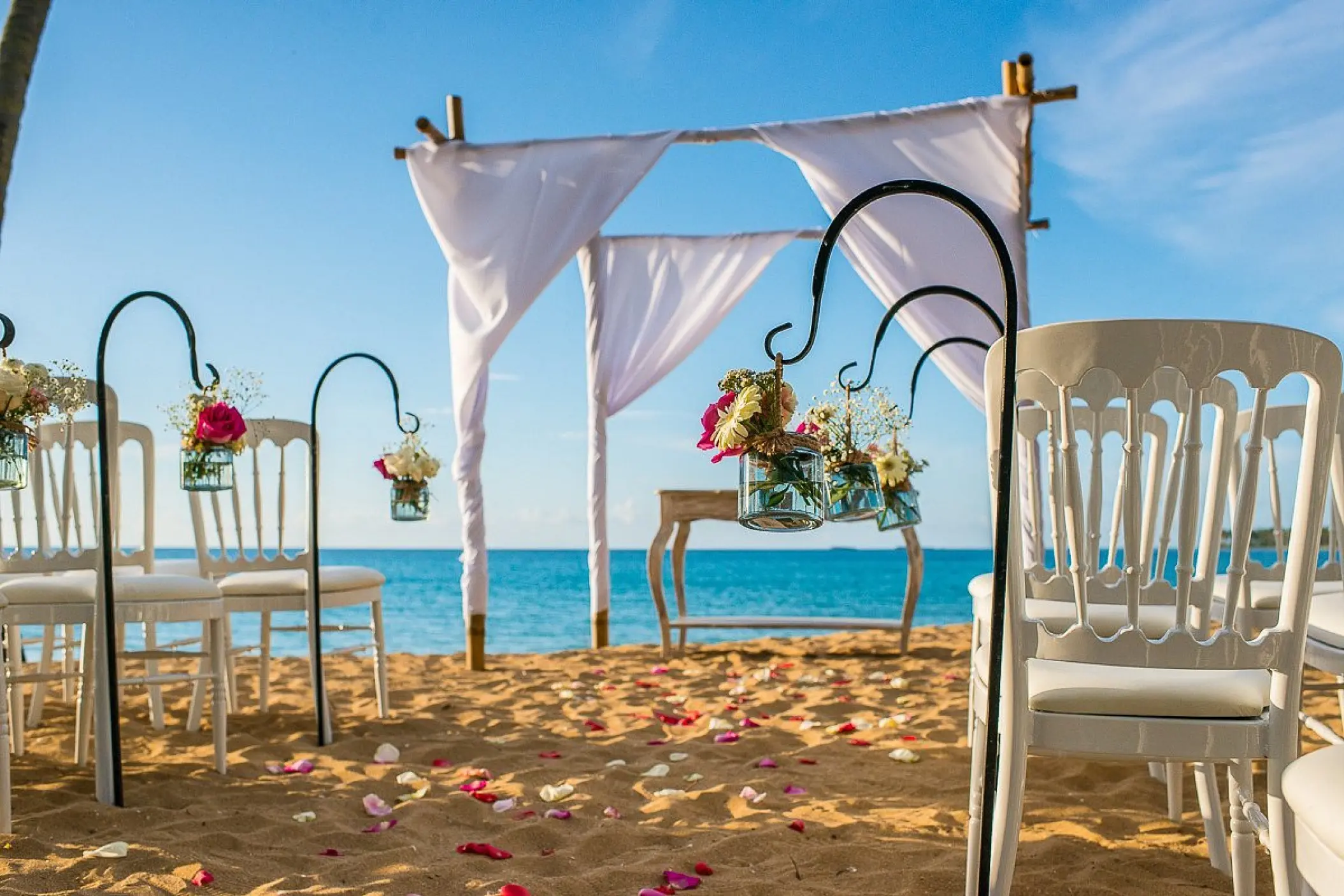 Beachfront wedding ceremony with white huppah and floral accents at Sublime Samaná, Samana