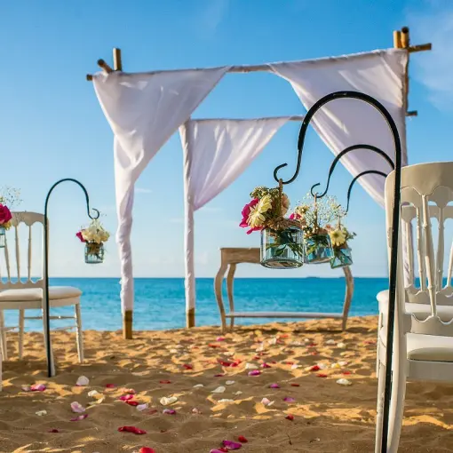 Beachfront wedding ceremony with white huppah and floral accents at Sublime Samaná, Samana