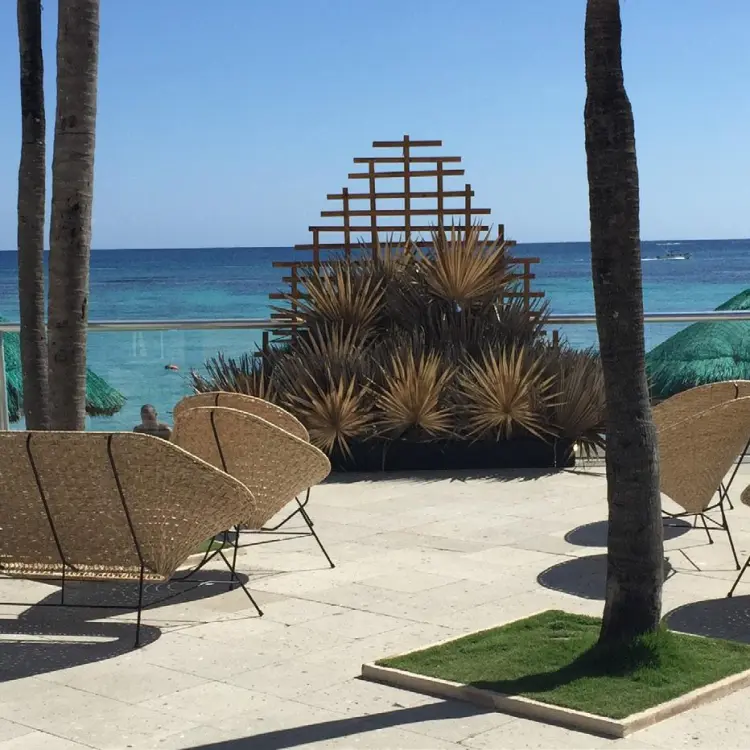 Sharky's terrace with lounge seating overlooking the ocean at Sunscape Akumal Beach, Tulum