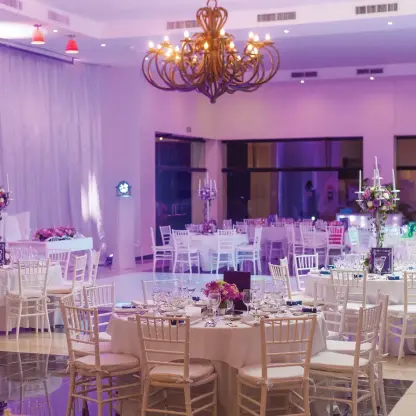 Indoor wedding reception setup with purple lighting in the ballroom at Sunscape Akumal, Tulum