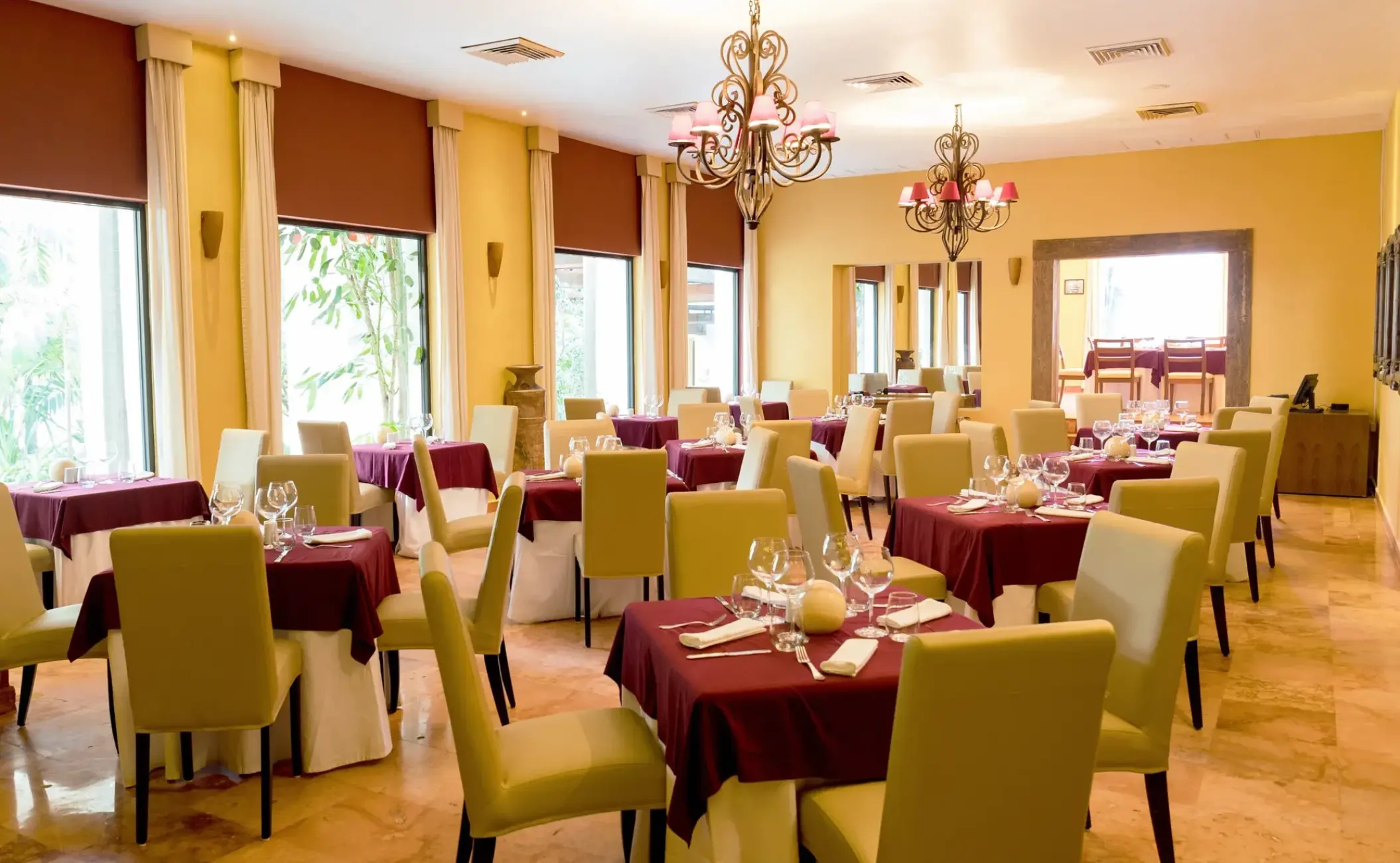 Indoor Italian restaurant with red tablecloths and chandeliers at Sunscape Akumal, Tulum