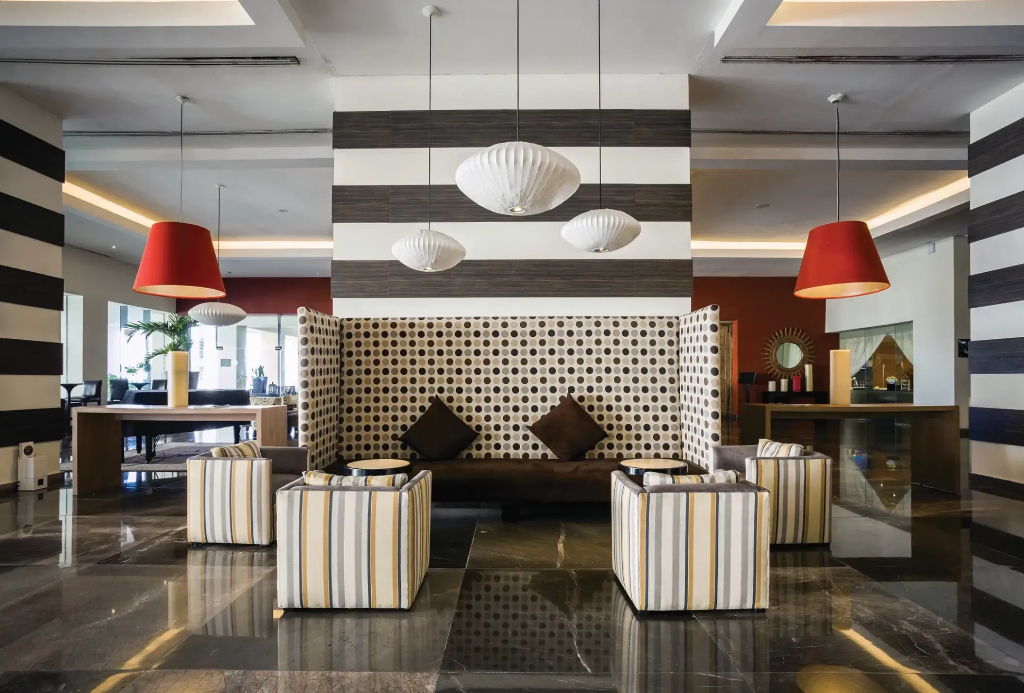 Modern lobby lounge with red and white pendant lights at Sunscape Akumal, Tulum