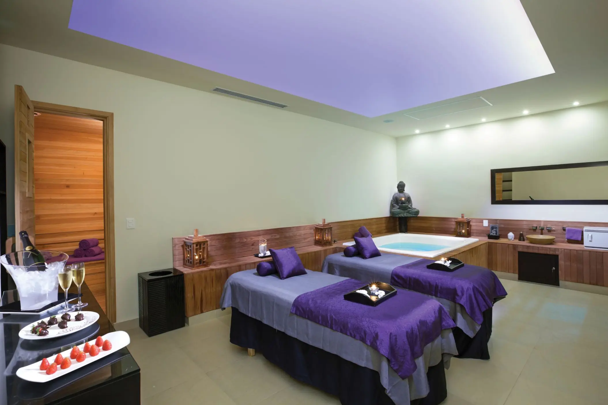Couples massage treatment room with whirlpool and purple linens at Sunscape Akumal, Tulum