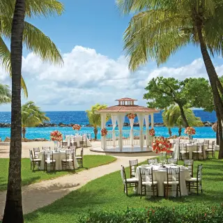 Beachfront wedding reception setup with white gazebo and garden tables at Sunscape Akumal Beach, Tulum