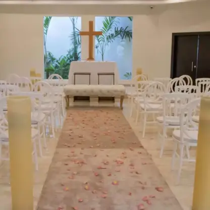 Chapel wedding ceremony setup with white chairs and a wooden cross at Sunscape Akumal, Tulum