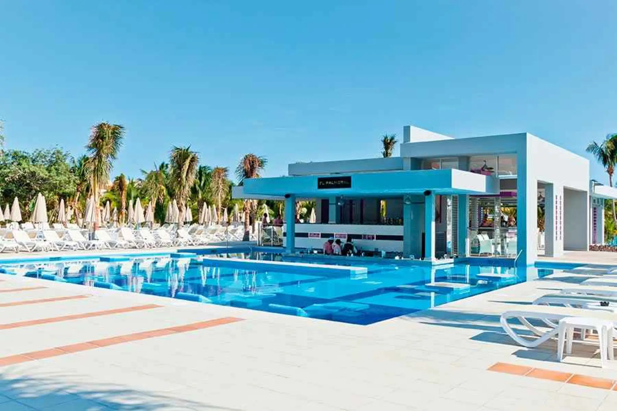 Swim-up bar and main pool with lounge chairs at Riu Palace Mexico, Playa Del Carmen