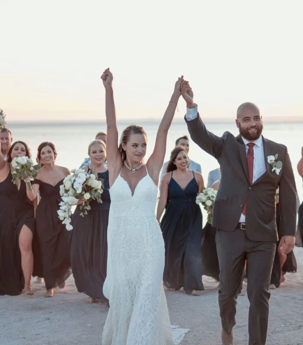 Bride and groom celebrating with their wedding party during a beach ceremony in Antigua