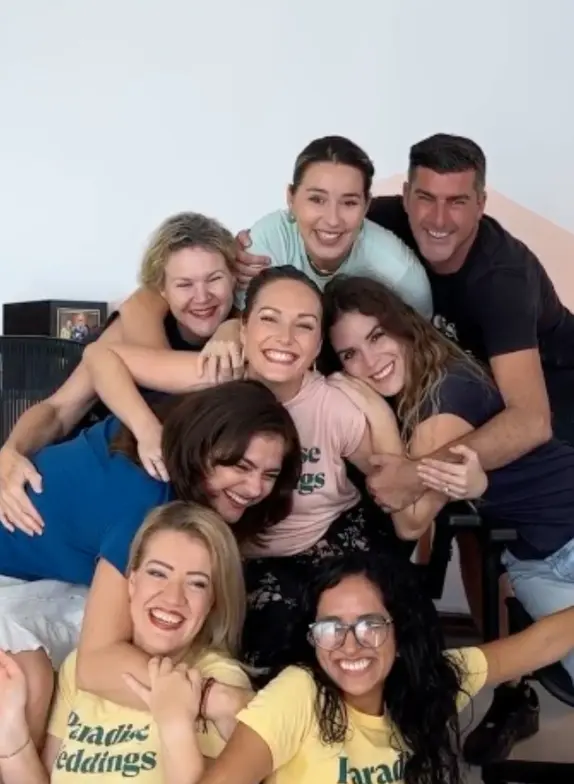 Group of Paradise Weddings planners smiling and hugging in a team photo