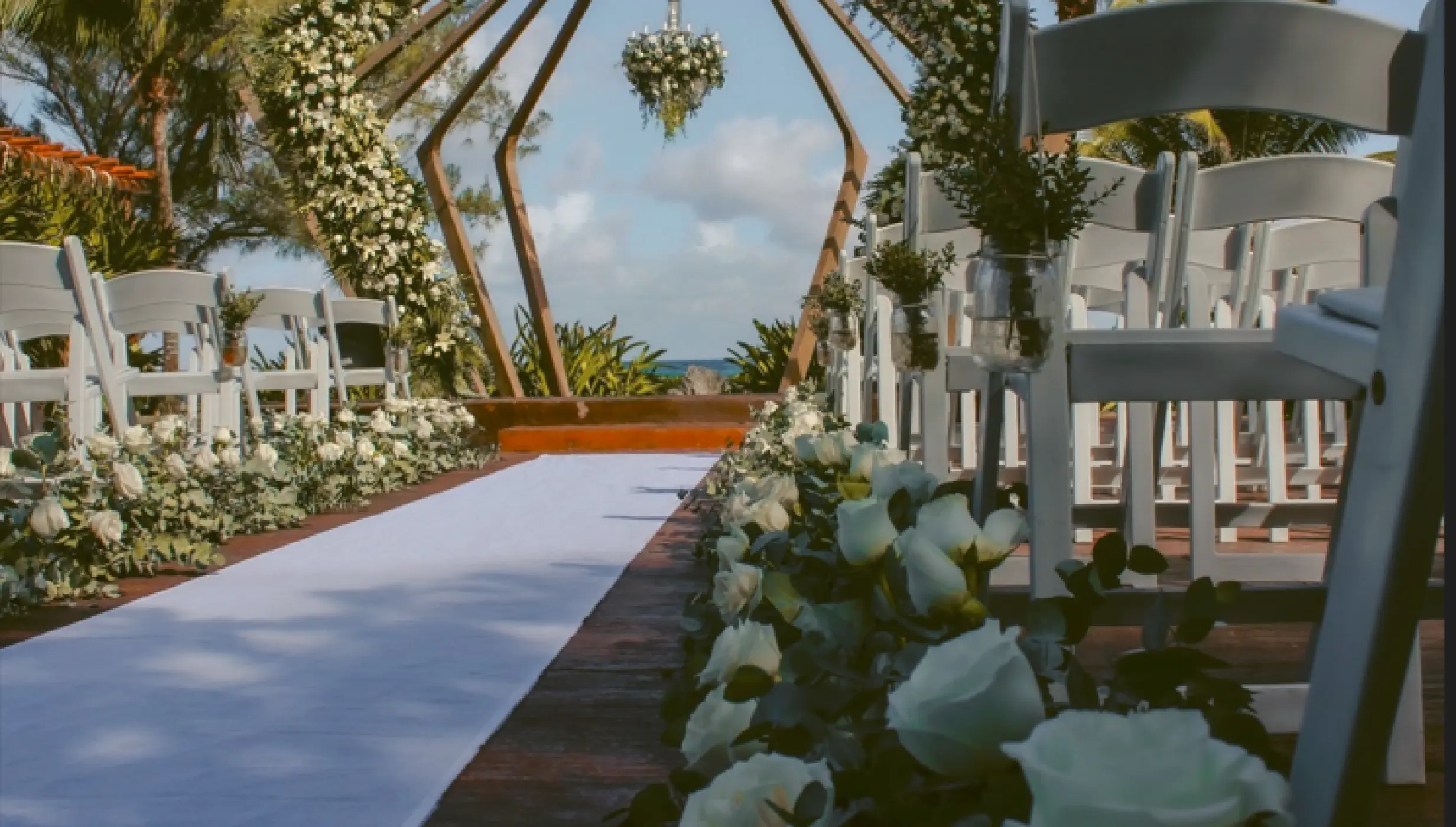 Wooden gazebo wedding ceremony with white roses at The Fives Beach, Playa Del Carmen