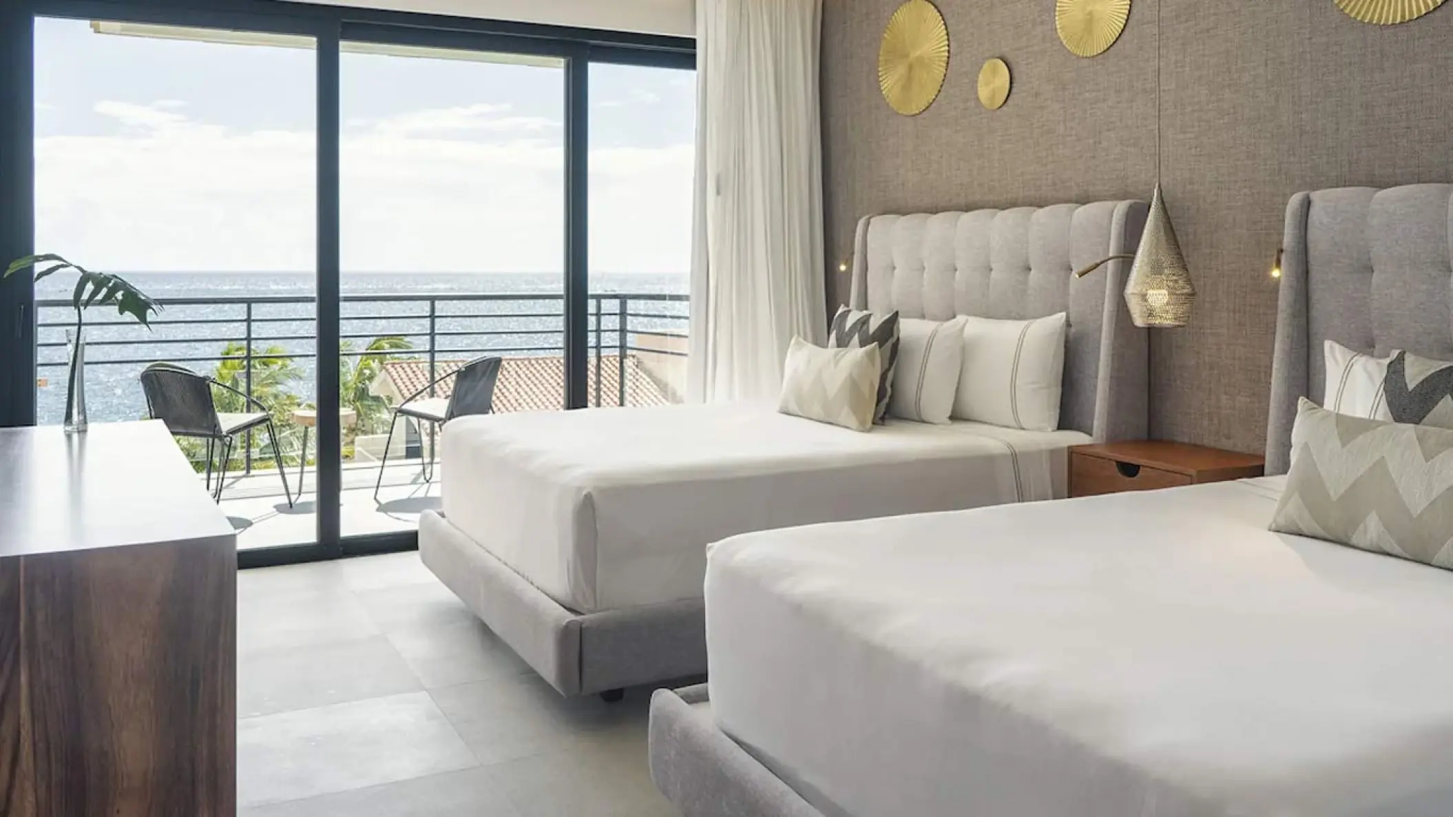 Modern oceanfront guest suite with two beds and a private balcony at The Fives Oceanfront, Riviera Maya