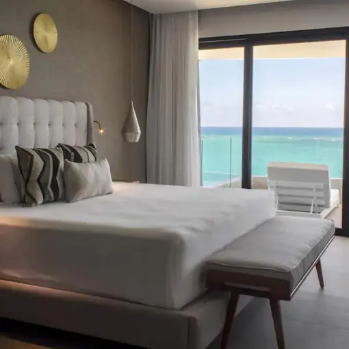 Modern suite with ocean view balcony and turquoise water at The Fives Oceanfront, Riviera Maya