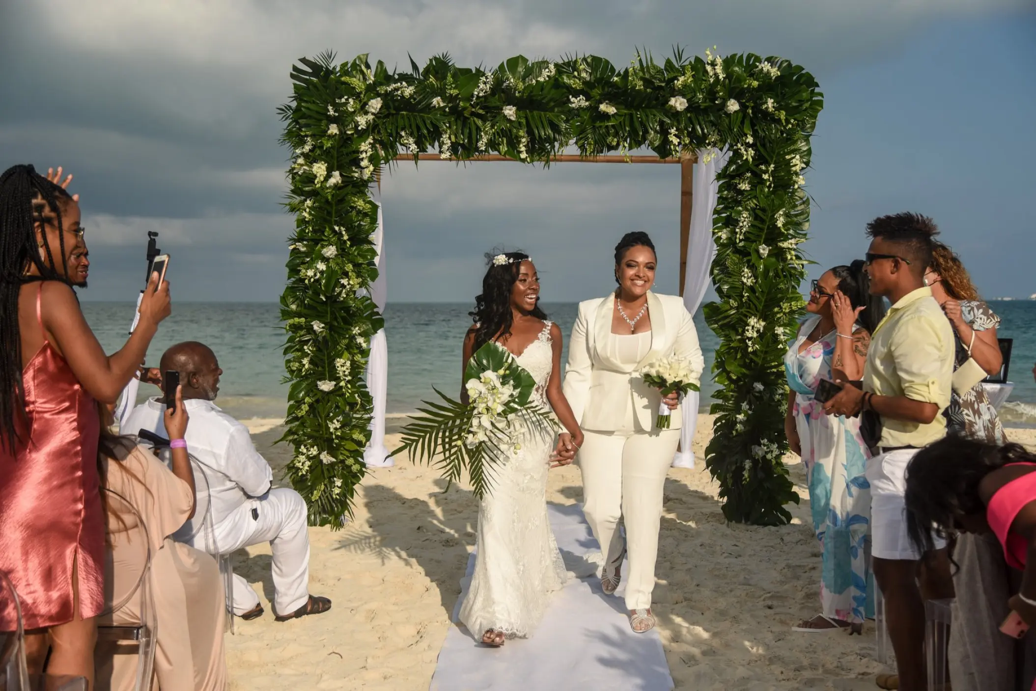 The couple walking down the aisle after a beach ceremony at TRS Coral Hotel, Cancun