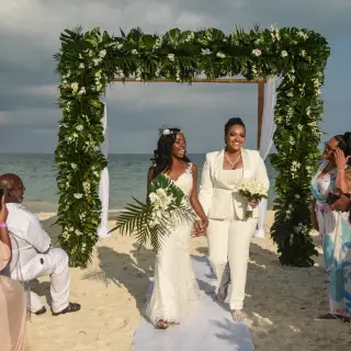 The couple walking down the aisle after a beach ceremony at TRS Coral Hotel, Cancun